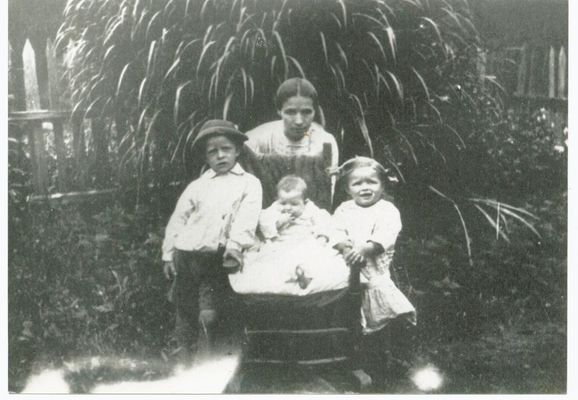 Grandma Medley
Grandma Medley (Margie Alice Carpenter) with Ernest Everett Medley, Baby Clema Frances Caudle and Rose Emma Caudill, taken in 1916.

Grandpa Medley (Thomas Jefferson) made the picket fence and they are in front of a huge Pampas grass plant that he got somewhere in his travels and planted in the yard. Mom said that he took really good care of his yard. This was on Mitchell's River, inside what is now the Reynolds Estate ...Mom said neighbors would get the "flowers" from the Pampas Grass to use for dusters..
