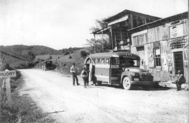 Rugby - Bookmobile Visit
This is a late 1940s or early 1950s photo showing a visit of the Grayson County Library's bookmobile to the Rugby Community.  Johnny Warren is the child coming from the bookmobile with books.  Conley Warren is standing behind Johnny.  Marvin Reedy is sitting on the porch of the store.  The other man is unidentified.  Courtesy of Judy Russell Powers.
