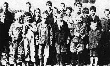 wallaceschool.jpg
Needmore (Wallace) School (Courtesy of Connie Knipp)
This is Needmore School around 1918, Carrie Countiss or Emily Holloway was the teacher. FRONT ROW LEFT TO RIGHT: Garnett Leonard, Moses Luther Goodson, Charles Thomas, Howard Goodson, Ester Leonard, Wilmer Mitchell, Malcom Mitchell. Second Row: Bertha Rush ( girl with braids), Rose Goodson ( face partly hidden), Stella McCracken ( showing her watch, it is 1 p.m.) Robert Leonard. Third Row: Howard McCracken, Samuel Mitchell, Gannaway Rush, William Goodson, Nellie Goodson, Ralph Goodson, Paul Goodson, Garnett, Esther,& Robert Leonard brothers & sister, Nellie & Ralph Goodson full brother & sister, Moses Luther Goodson, a half brother, Howard & Stella McCracken, brother & sister, Howard, Rose, William, & Paul Goodson, brother & sister, Wilmar, Malcom, & Samuel Mitchell, brothers, Gannaway & Bertha Rose, brother & sister.

